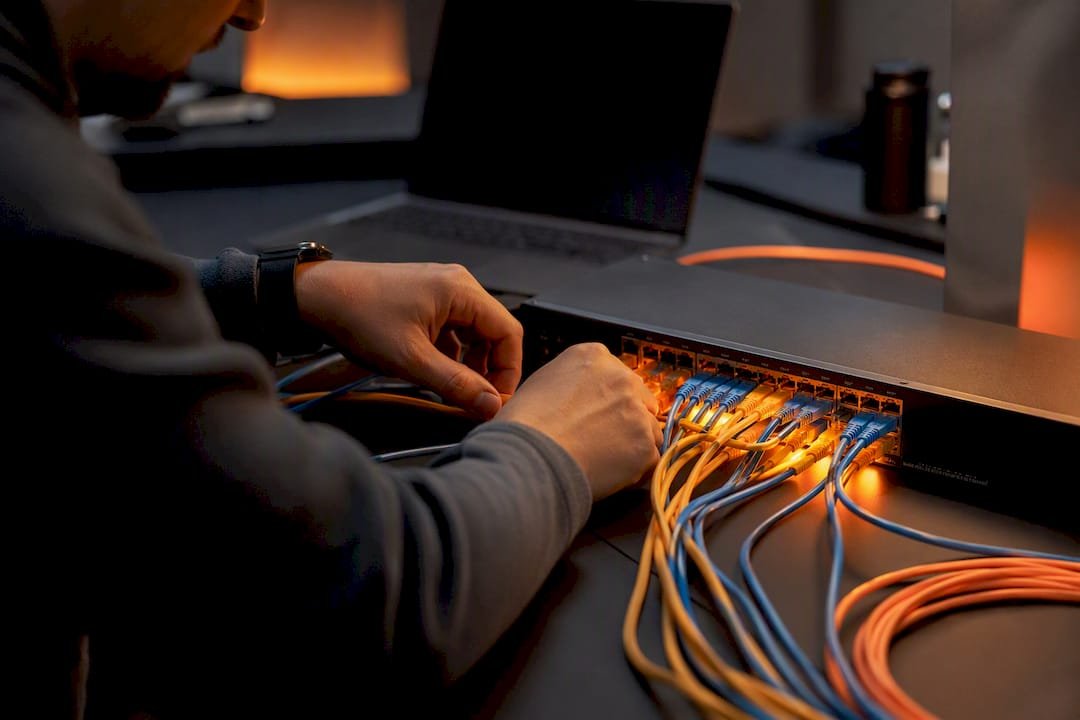 Hands wiring network hardware with glowing lights
