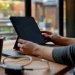 Hands holding tablet with dark screen