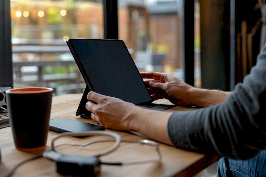 Hands holding tablet with dark screen